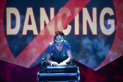 Ivonne Kalter leaning over a record player with the word DANCING struck through in the background