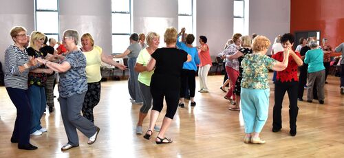 A hall of participants dancing in pairs