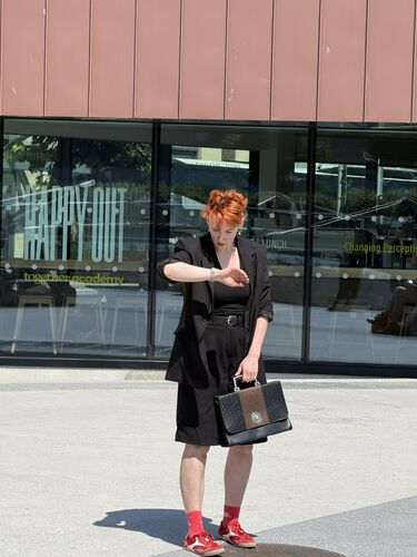 A woman looking at her watch and with a briefcase in her other hand