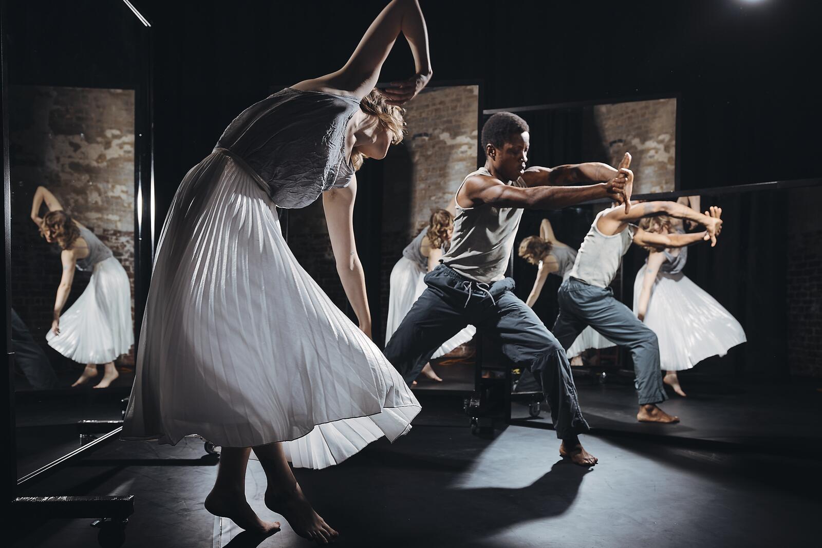 Dancers in a movement surrounded by the mirrors